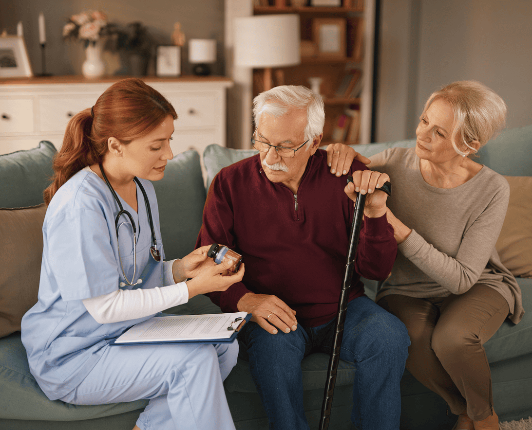 Nurse discussing medication with elderly couple.
